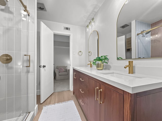 312 Meadowlark Dr, Richardson, TX 75080 - full bathroom with double vanity, wood finished floors, and a stall shower
