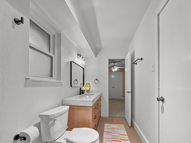 312 Meadowlark Dr, Richardson, TX 75080 - half bathroom featuring wood finished floors, vanity, ceiling fan, and a textured wall