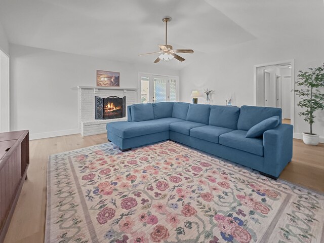312 Meadowlark Dr, Richardson, TX 75080 - living area with ceiling fan, light wood finished floors, a brick fireplace, and lofted ceiling