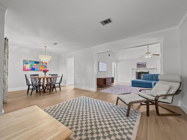 312 Meadowlark Dr, Richardson, TX 75080 - living area featuring wood finished floors, a chandelier, crown molding, a fireplace, and ceiling fan