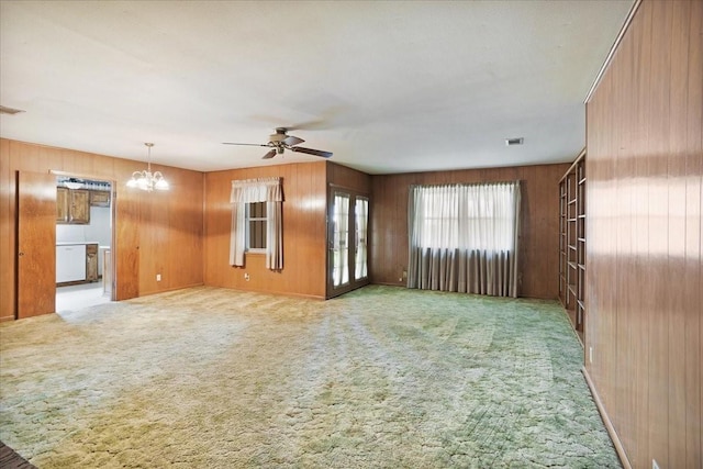 2909 Dover Dr, Sherman, TX 75092 - unfurnished living room with ceiling fan, wooden walls, a chandelier, and carpet flooring