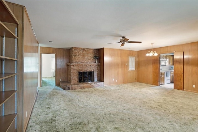 2909 Dover Dr, Sherman, TX 75092 - unfurnished living room featuring wooden walls, a ceiling fan, a fireplace, a chandelier, and carpet