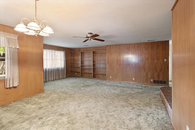 2909 Dover Dr, Sherman, TX 75092 - carpeted empty room featuring wood walls, a chandelier, and a ceiling fan