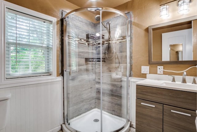 902 Travis Ave, Alvarado, TX 76009 - bathroom featuring vanity, a textured wall, wainscoting, and a stall shower
