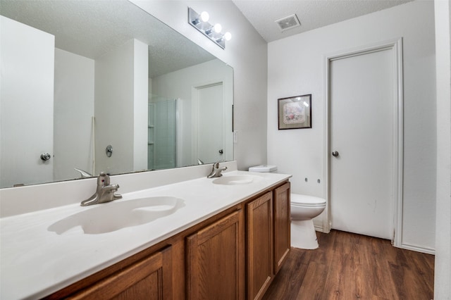 2007 Brazos Ct, Grand Prairie, TX 75052 - bathroom with wood finished floors, double vanity, a shower, and a textured ceiling