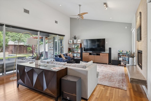 613 N Bailey Ave, Fort Worth, TX 76107 - living area featuring high vaulted ceiling, light wood-style floors, ceiling fan, and a large fireplace