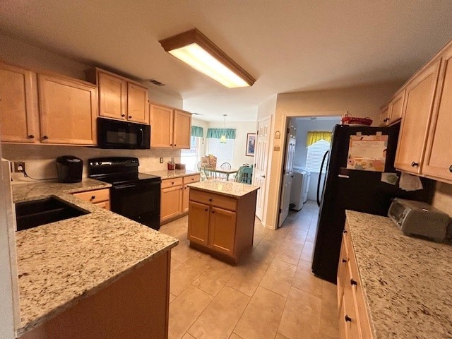 3900 Chimney Rock Dr, Denton, TX 76210 - kitchen with black appliances, a kitchen island, light stone countertops, and light tile patterned flooring