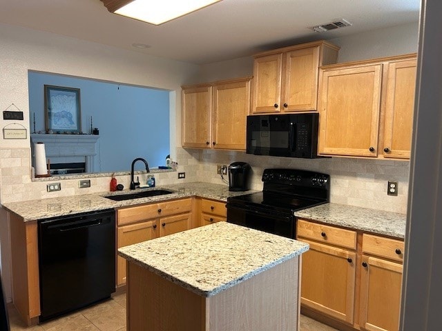3900 Chimney Rock Dr, Denton, TX 76210 - kitchen featuring black appliances, tasteful backsplash, light brown cabinetry, and light stone countertops