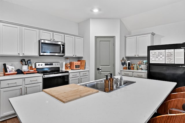 2806 Peony Dr, Sherman, TX 75092 - kitchen with appliances with stainless steel finishes, light countertops, a center island with sink, and a breakfast bar