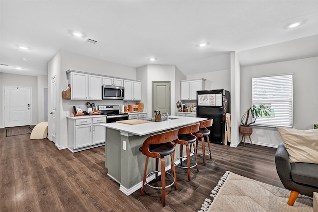 2806 Peony Dr, Sherman, TX 75092 - kitchen with appliances with stainless steel finishes, open floor plan, recessed lighting, dark wood-style floors, and a breakfast bar area