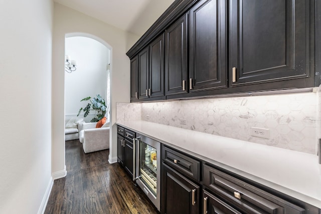 13122 Dolomite Dr, Frisco, TX 75035 - bar area with dark wood-style floors, backsplash, and arched walkways