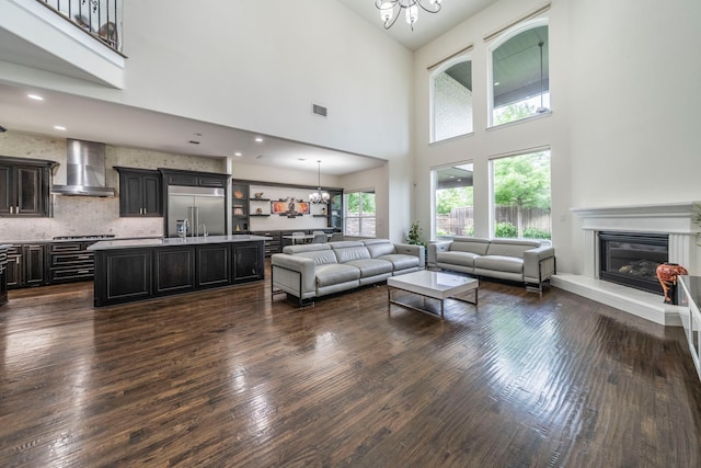 13122 Dolomite Dr, Frisco, TX 75035 - living area with a chandelier, dark wood-style floors, a glass covered fireplace, and a high ceiling