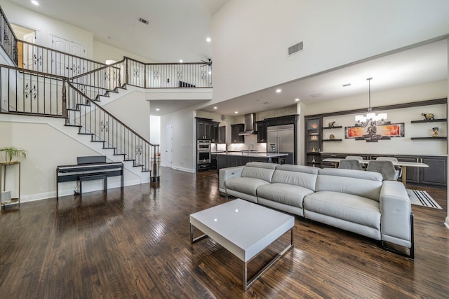 13122 Dolomite Dr, Frisco, TX 75035 - living room with a chandelier, stairs, wood finished floors, a towering ceiling, and recessed lighting
