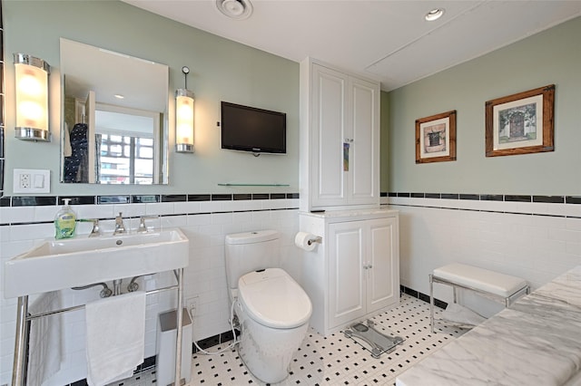 3525 Turtle Creek Blvd Unit 4E, Dallas, TX 75219 - bathroom featuring tile walls and wainscoting