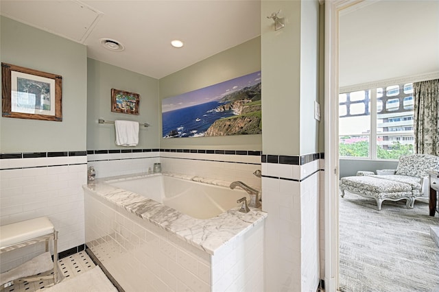 3525 Turtle Creek Blvd Unit 4E, Dallas, TX 75219 - bathroom featuring tile walls, a bath, and wainscoting