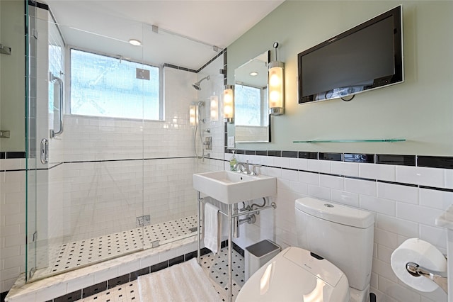 3525 Turtle Creek Blvd Unit 4E, Dallas, TX 75219 - bathroom with tile walls, a stall shower, and wainscoting