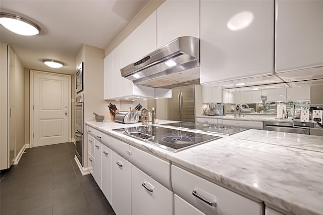 3525 Turtle Creek Blvd Unit 4E, Dallas, TX 75219 - kitchen featuring ventilation hood, stainless steel appliances, white cabinets, dark tile patterned floors, and light stone countertops