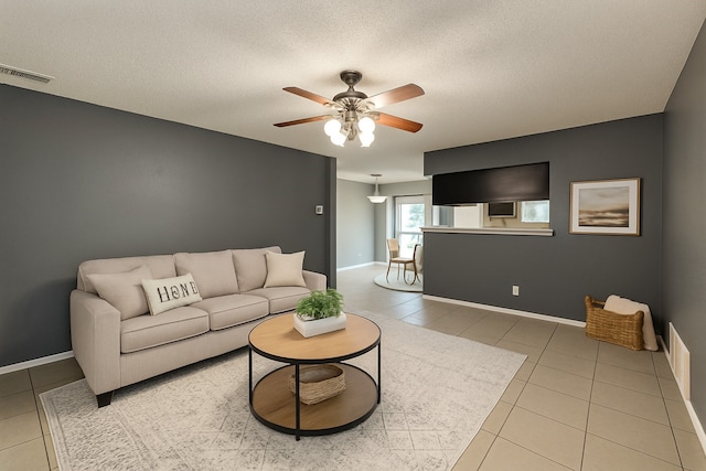 202 Modene Ave, Waxahachie, TX 75165 - living room featuring a ceiling fan, light tile patterned floors, and a textured ceiling