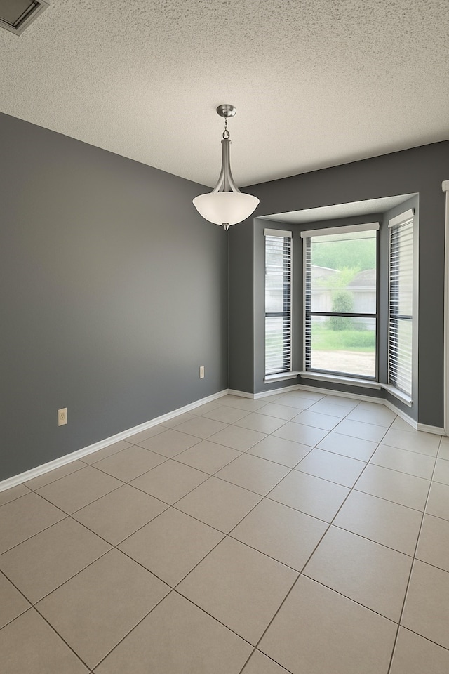 202 Modene Ave, Waxahachie, TX 75165 - spare room featuring a textured ceiling and light tile patterned floors