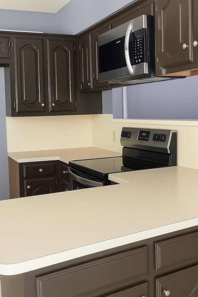 202 Modene Ave, Waxahachie, TX 75165 - kitchen with appliances with stainless steel finishes, light countertops, and dark brown cabinetry