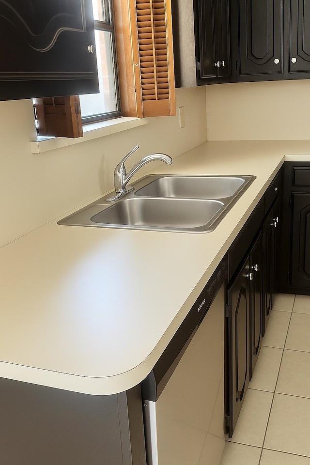 202 Modene Ave, Waxahachie, TX 75165 - kitchen featuring dishwashing machine, dark cabinets, light tile patterned floors, and light countertops