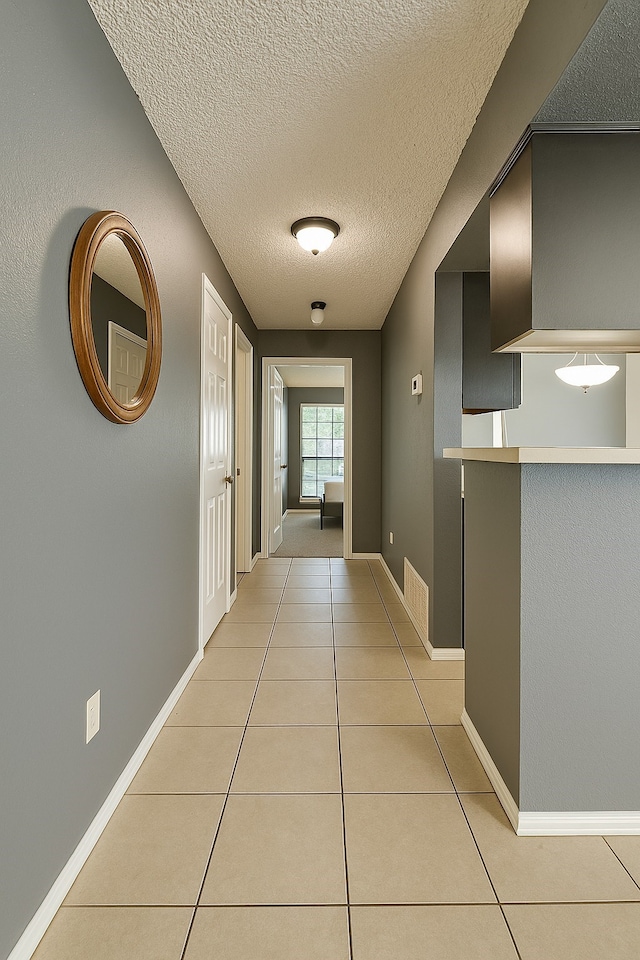 202 Modene Ave, Waxahachie, TX 75165 - corridor featuring light tile patterned floors and a textured ceiling