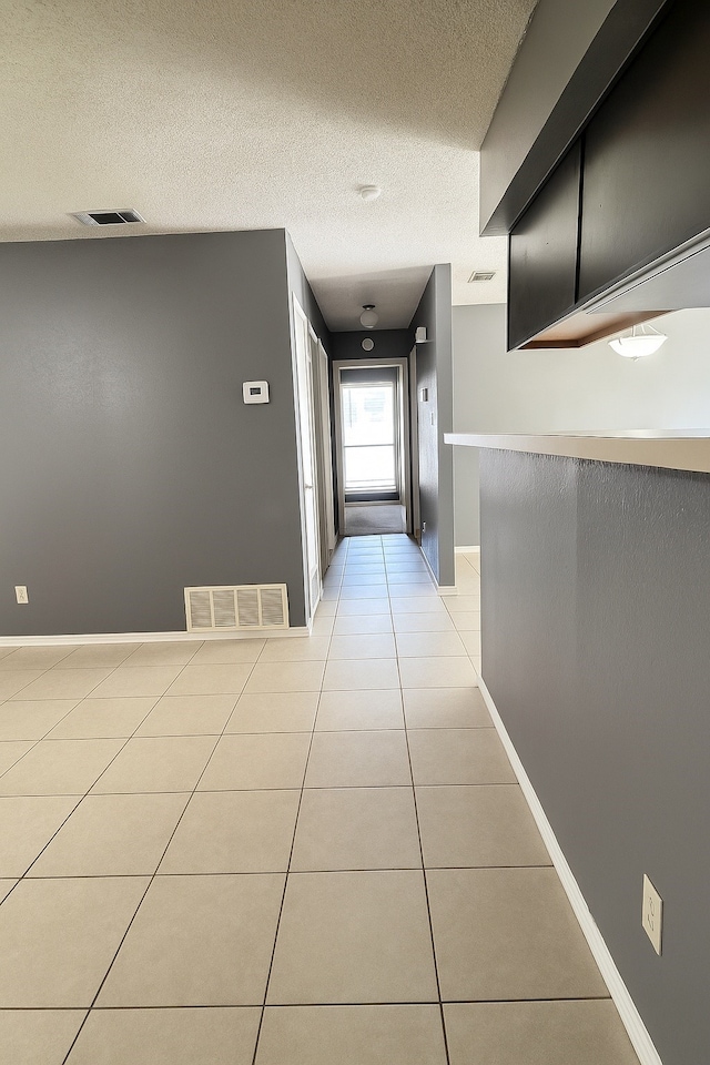 202 Modene Ave, Waxahachie, TX 75165 - hallway featuring light tile patterned floors and a textured ceiling