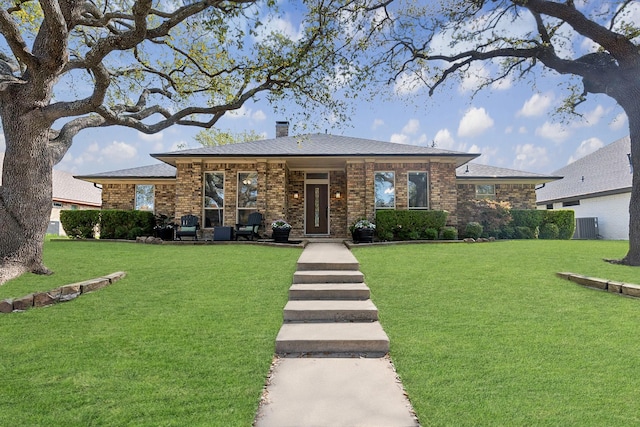 10216 Shadow Way, Dallas, TX 75243 - view of front of house featuring a chimney, a front yard, and brick siding
