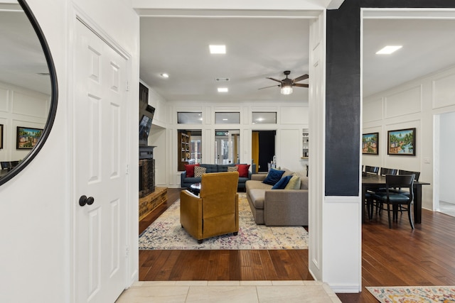 10216 Shadow Way, Dallas, TX 75243 - living area featuring a ceiling fan, wood finished floors, a decorative wall, and a fireplace
