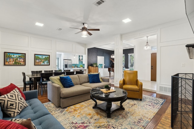10216 Shadow Way, Dallas, TX 75243 - living room featuring a ceiling fan, a decorative wall, ornate columns, and wood finished floors
