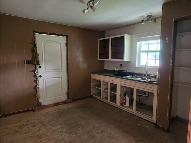 1000 Harrison St, Commerce, TX 75428 - kitchen featuring open shelves, dark countertops, and wood walls