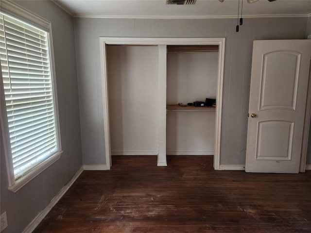 1000 Harrison St, Commerce, TX 75428 - unfurnished bedroom with crown molding, dark wood finished floors, a closet, and multiple windows