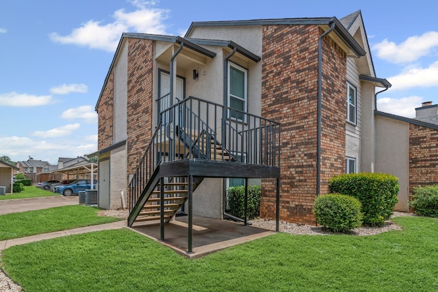 825 W Harwood Rd Unit A, Hurst, TX 76054 - rear view of property with stucco siding, brick siding, and a lawn
