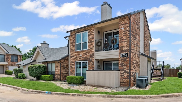 825 W Harwood Rd Unit A, Hurst, TX 76054 - view of side of home featuring a chimney, brick siding, stairs, and a balcony