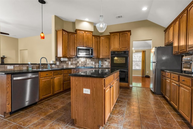 6505 Taprock Dr, Mckinney, TX 75070 - kitchen with stainless steel appliances, a kitchen island, brown cabinetry, tasteful backsplash, and lofted ceiling