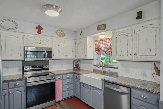 180 Vz County Road 4202, Canton, TX 75103 - kitchen featuring stainless steel appliances, gray cabinets, a textured ceiling, dark wood-style flooring, and dark countertops