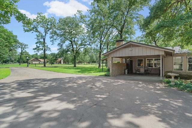 180 Vz County Road 4202, Canton, TX 75103 - view of side of property with a chimney, driveway, a yard, board and batten siding, and a carport