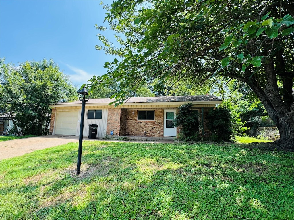 1209 Lynn St, Weatherford, TX 76086 - ranch-style house featuring an attached garage, brick siding, a front lawn, and driveway