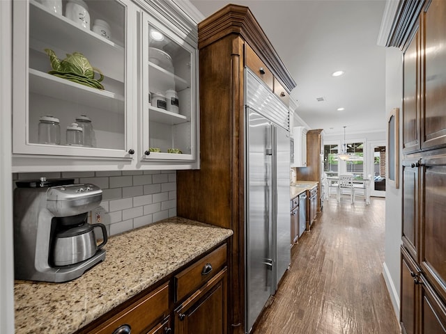 3309 Laurel Fork Dr, Mckinney, TX 75070 - kitchen featuring dark wood-type flooring, glass insert cabinets, light stone counters, decorative backsplash, and recessed lighting
