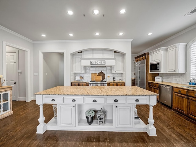 3309 Laurel Fork Dr, Mckinney, TX 75070 - kitchen with stainless steel appliances, a kitchen bar, crown molding, white cabinetry, and a kitchen island