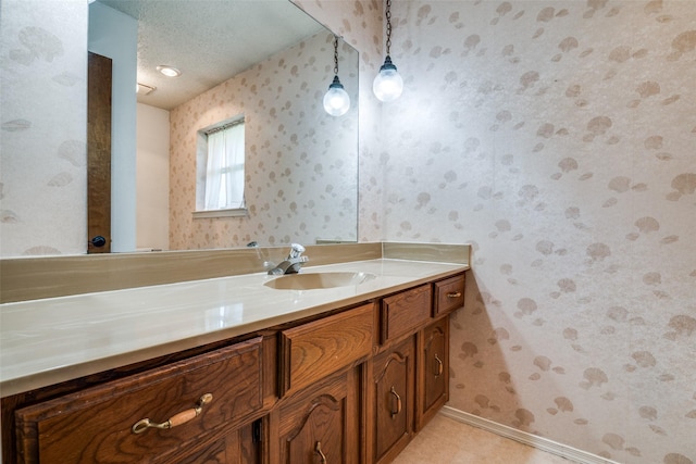 406 Los Santos Dr, Garland, TX 75043 - bathroom featuring wallpapered walls, vanity, and a textured ceiling