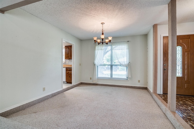 406 Los Santos Dr, Garland, TX 75043 - foyer featuring a chandelier, a textured ceiling, and light carpet