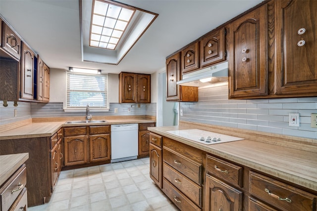 406 Los Santos Dr, Garland, TX 75043 - kitchen featuring white appliances, under cabinet range hood, light countertops, light floors, and backsplash