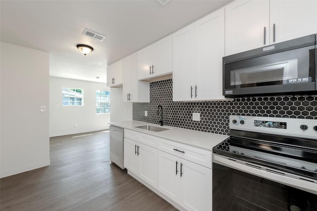 3924 Dismount St, Dallas, TX 75211 - kitchen with stainless steel appliances, tasteful backsplash, light countertops, white cabinetry, and light wood-style flooring