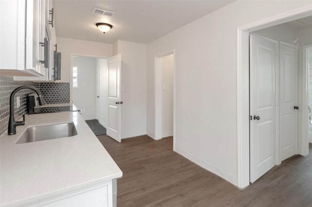3924 Dismount St, Dallas, TX 75211 - kitchen featuring wood finished floors, white cabinetry, and tasteful backsplash