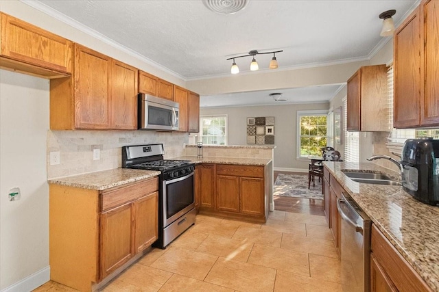 3605 Stadium Dr, Fort Worth, TX 76109 - kitchen with appliances with stainless steel finishes, backsplash, a peninsula, light stone countertops, and ornamental molding