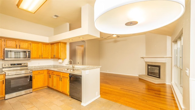 2512 Woodhaven Dr, Flower Mound, TX 75028 - kitchen with appliances with stainless steel finishes, open floor plan, light wood-style flooring, and a peninsula