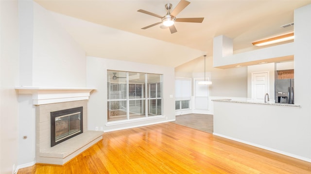 2512 Woodhaven Dr, Flower Mound, TX 75028 - unfurnished living room featuring wood finished floors, ceiling fan, vaulted ceiling, and a fireplace