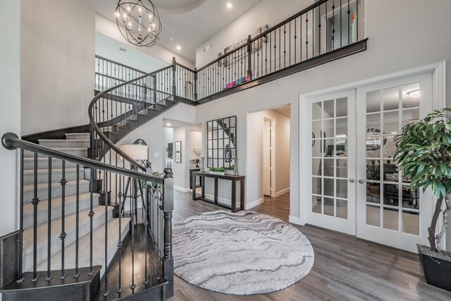 407 Emerson Dr, Rockwall, TX 75087 - staircase featuring french doors, wood finished floors, a chandelier, and a towering ceiling