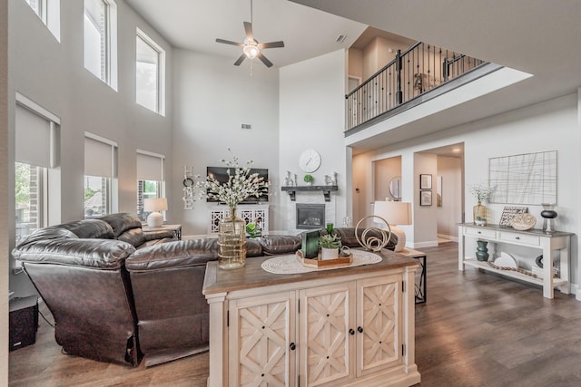 407 Emerson Dr, Rockwall, TX 75087 - living area featuring a towering ceiling, ceiling fan, a glass covered fireplace, dark wood-style floors, and plenty of natural light